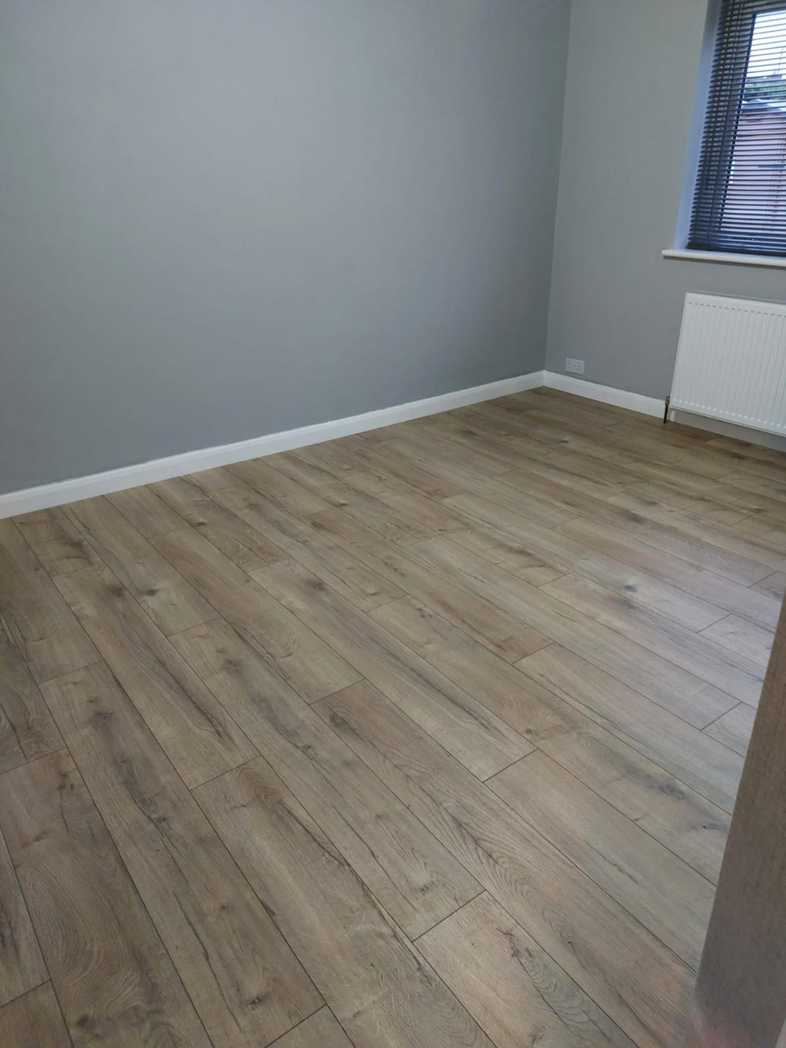 Close view of fitted laminate floor and skirting